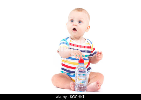 Mignon petit garçon étonné en chemise colorée avec du lait Banque D'Images