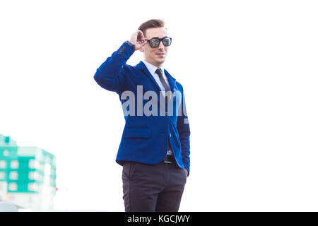 Dans busunessman attractive et costume bleu lunettes stand o Banque D'Images