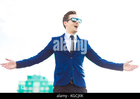 Dans busunessman attractive et costume bleu lunettes stand o Banque D'Images
