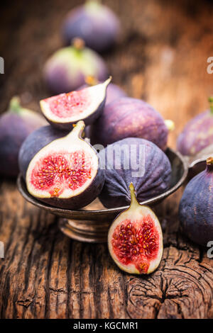 Fig. un peu de figues dans un bol sur un vieux fond de bois. Banque D'Images