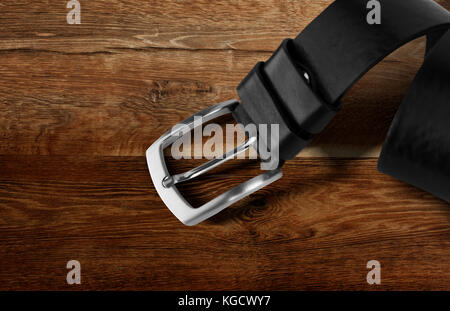 Ceinture homme en cuir noir isolé sur fond de bois. with clipping path. Banque D'Images