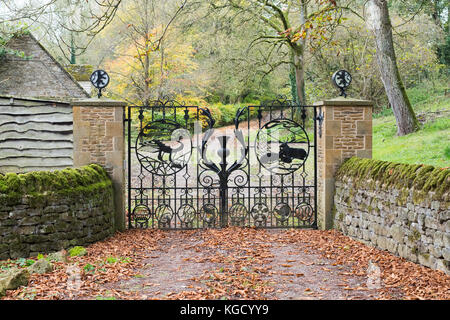 Portes en fer forgé décoratif avec un thème écossais distinctif dans Little Tew, Oxfordshire, Angleterre Banque D'Images