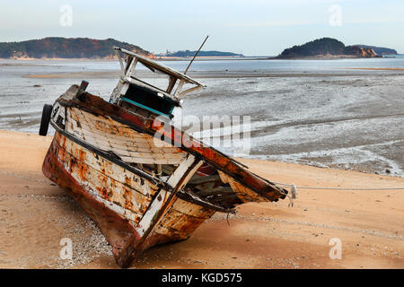 La détérioration de l'ancien bateau de pêche sur une plage de sable Banque D'Images