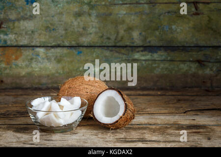 Tout frais et les couper en deux morceaux de noix de coco Coco sur fond de bois with copy space Banque D'Images