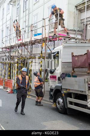 Les travailleurs démontent les échafaudages d'un magasin à St Ives, en Cornwall, au Royaume-Uni Banque D'Images