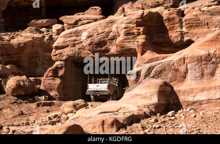 Juxtaposition de 4 roues motrices véhicule stationné dans le vieux tombeau nabatéen sculpté, Petra, Jordanie, Moyen-Orient Banque D'Images