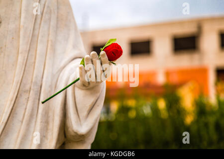 Statue de notre-Dame de Medjugorje, la Sainte Vierge Marie, à la main rose rouge Banque D'Images