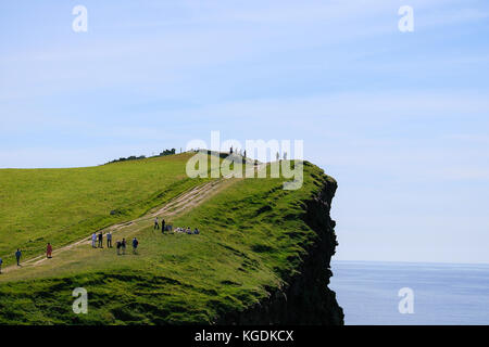 Détente Tourisme marche vers le haut de la partie nord des falaises de Moher dans le comté de Clare sur une journée d'été juin - les touristes les plus populaires destinations en Irlande Banque D'Images