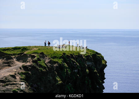 Détente Tourisme marche vers le haut de la partie nord des falaises de Moher dans le comté de Clare sur une journée d'été juin - les touristes les plus populaires destinations en Irlande Banque D'Images