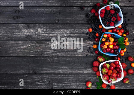 Dans des bols de fruits frais de la forêt sur un fond de bois. Vue de dessus Banque D'Images