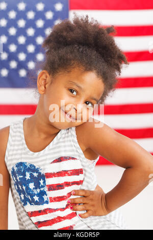 Petite fille afro-américaine avec le drapeau américain sur un arrière-plan