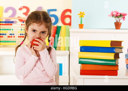 Preschool girl eating red apple Banque D'Images