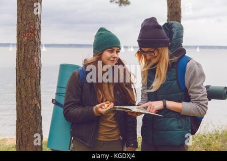 Deux femme avec look tendance direction la recherche sur plan de situation tout en se déplaçant à la nature sauvage Banque D'Images