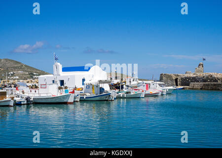 Des bateaux de pêche à une petite chapelle orthodoxe, port de Naoussa, Paros, Cyclades, Mer Égée, Grèce Banque D'Images