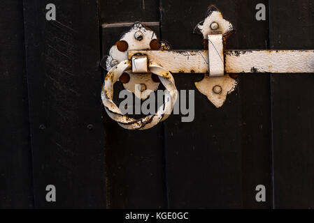 La porte en bois brun foncé avec charnière rouillée. érodés, charnière métal corrodé sur porte en bois rustique. Banque D'Images