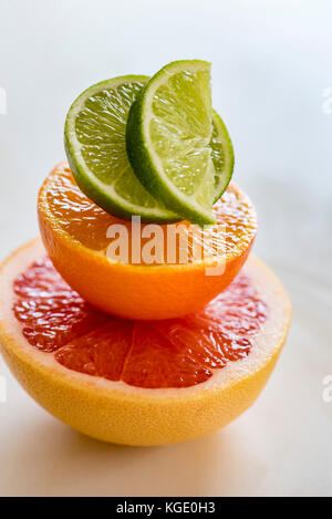 La moitié des tas de couleurs agrumes, vue de dessus, macro. pamplemousse, orange et citron vert les moitiés de fruits, macro, à la verticale. Banque D'Images