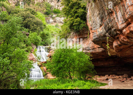 Cascades cascade sur les rochers rouges en vertu de l'Espai natural Sant Miquel del fai monastère en Catalogne, espagne. Banque D'Images