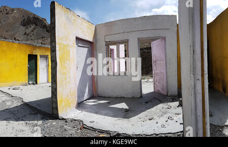 Murs de maison en ruine sans un toit, jaune, rose et blanc avec des ouvertures de surfaces vides portes et fenêtres, ciel bleu. Banque D'Images