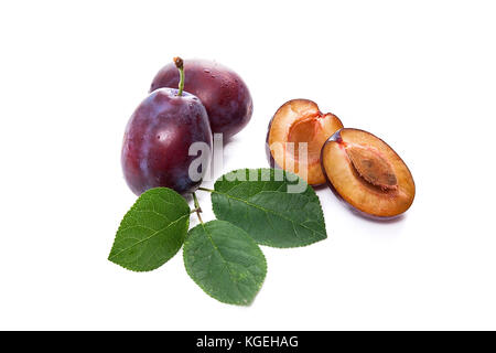 Ensemble de deux et la moitié des prunes juteux doux avec de grandes feuilles vert isolé sur un fond blanc. Banque D'Images