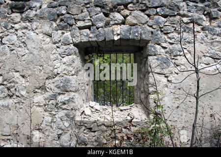 Ceklin Village, le Monténégro - une fenêtre avec grilles en fer sur le mur de pierre d'une maison abandonnée Banque D'Images