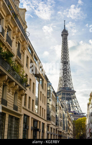 Vue d'une rue adjacente de la majestueuse Tour Eiffel dans son voisinage immédiat avec des immeubles parisiens au premier plan. Banque D'Images