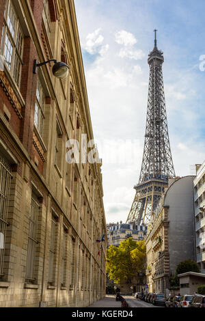 Vue d'une rue adjacente de la majestueuse Tour Eiffel dans son voisinage immédiat avec des immeubles parisiens au premier plan. Banque D'Images