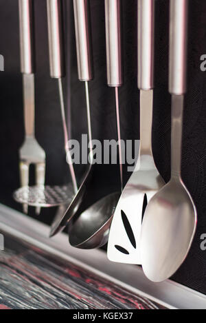 Cuisine avec cuisine noir accessoires suspendus sur un fond de tuile Banque D'Images