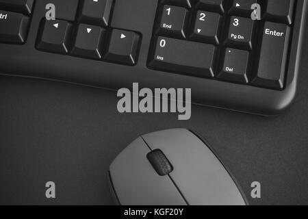 Clavier noir et gris souris sans fil sur un bureau. noir et blanc. close up. Banque D'Images