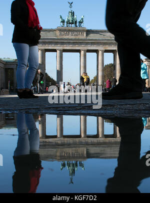 Berlin, Allemagne. 07 novembre 2017. La porte de Brandebourg reflétée par une flaque d'eau sur la place de Paris à Berlin, en Allemagne, le 7 novembre 2017. Crédit : Ralf Hirschberger/dpa-Zentralbild/dpa/Alamy Live News Banque D'Images