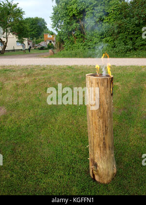 Nica, la Lettonie - le 23 juin 2013 : coupe verticale de bois sec scié journal est tiré comme bougie torche géante ou le songe d'une journée de célébration. Banque D'Images