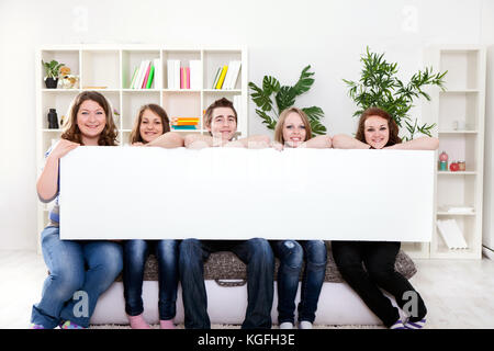 Groupe de jeunes adolescent smiling holding blank banner en face d'eux Banque D'Images