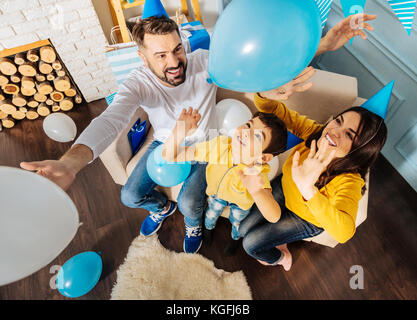 Famille heureuse de lancer des ballons d'anniversaire pendant Banque D'Images