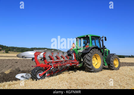 Salo, Finlande - le 22 août 2015 : agriculteur exploite sans nom 6630 John Deere et agrolux charrue à puontin peltopaivat sur le terrain de la récolte agricole Banque D'Images