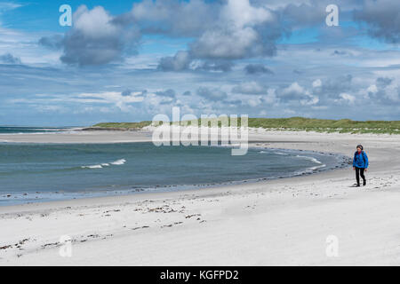 Une femme marche sur Howmore Beach, South Uist, dans les Hébrides extérieures, en Écosse. Banque D'Images