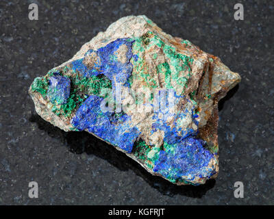 La prise de vue macro des eaux minérales naturelles rock specimen - bleu azurite et malachite verte sur les matières premières sur la pierre de granit sombre arrière-plan d'Oural, Russie Banque D'Images