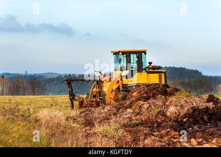 Drague avec un peu de fumier remorque chargement pour le champ de la fécondation. machine agricole pour la fertilisation de la bouse de vache. Banque D'Images