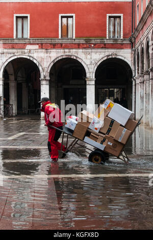 Venise, Italie. 07Th novembre, 2017. Un travailleur livrer pendant une marée haute le 7 novembre 2017 à Venise, Italie. Banque D'Images