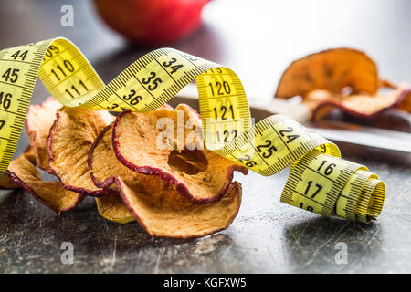 Des tranches de pommes séchées et ruban à mesurer. alimentation concept. Banque D'Images