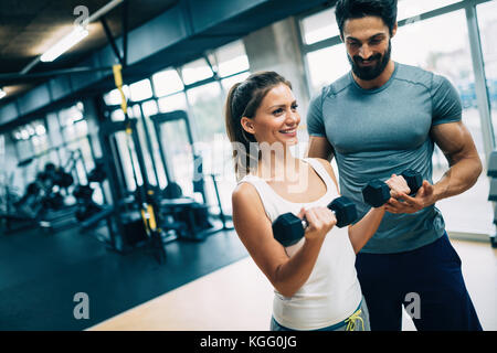 Belle jeune femme faisant des exercices avec un entraîneur personnel Banque D'Images