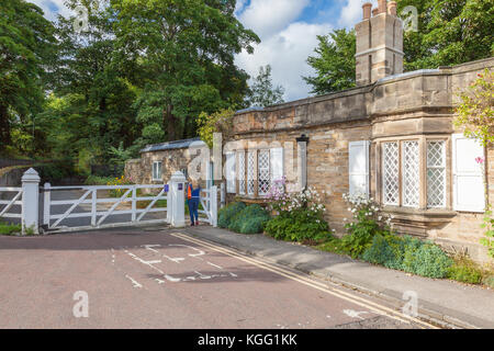 Une femme fait son chemin passé l'ancien Cottage sans frais et Gate sur Quarryheads lane, à l'égard de Bailey et Prebends bridge, Durham, Royaume-Uni Banque D'Images