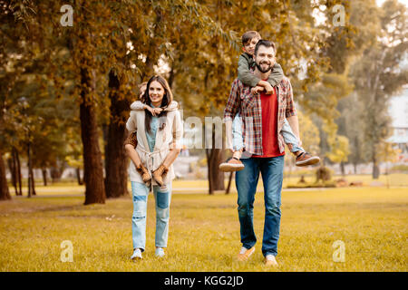 Donner aux enfants les parents piggyback ride Banque D'Images