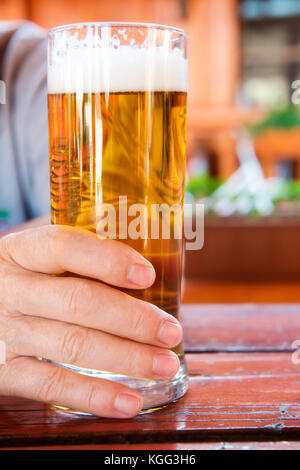 Homme main tenant un verre de bière pression Banque D'Images