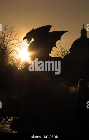 Un dragon statue respirer une boule de feu avec une cathédrale dans le fond. Banque D'Images