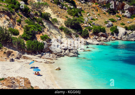 Vouti beach, l'île de Céphalonie, Grèce. Les gens se détendre à la plage. La plage est entourée de fleurs. Banque D'Images