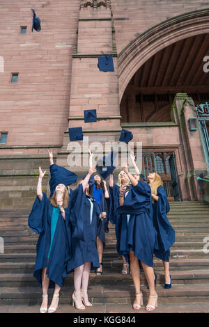 Les diplômés de sexe féminin célébrer à la cathédrale anglicane de Liverpool en jetant leurs conseils de mortier dans l'air. Banque D'Images