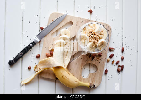 Chia pudding banane yogourt décoré avec des tranches de bananes mûres et arachides Banque D'Images