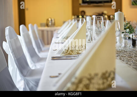 Photo de détail table de mariage avec l'accent sur des serviettes de papier décoratif en beige, la couleur d'or. table vide avec vin et verres de champagne, sel Banque D'Images