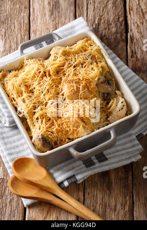 La nourriture américaine : avec des spaghetti tetrazzini à, champignons, fromage, poulet close-up dans un plat allant au four, sur la table verticale. Banque D'Images