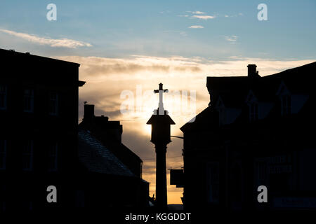 Croix de la Place du Marché au lever du soleil à Stow On The Wold, Cotswolds, Gloucestershire, Angleterre. Silhouette Banque D'Images