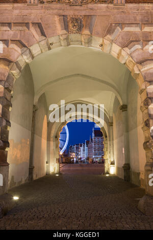 Rue Pavée et passerelle allumé lors de l'historique porte verte à la principale ville de Gdansk, en Pologne, dans la soirée. Banque D'Images